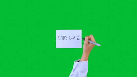 Arzt-Schreibt-Sars-cov-2-Auf-Papier-Mit-Grünem-Bildschirm